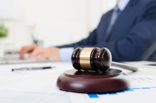 gavel sitting on attorney's desk with attorney working in background