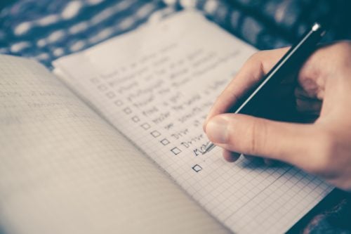 A person's hand writing in a notebook