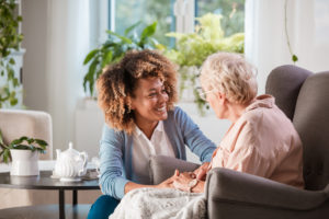 Friendly nurse supporting an eldery lady