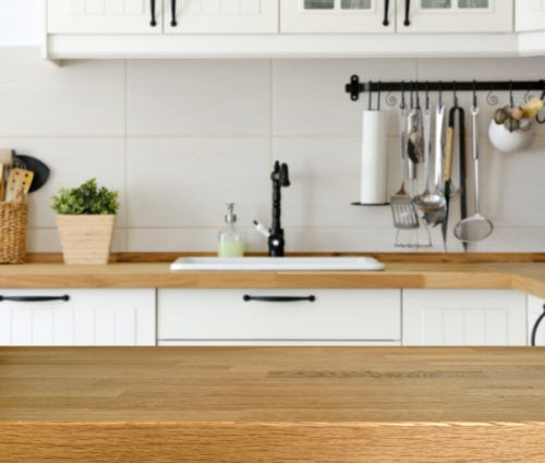 Wooden table with kitchen counter and sink background