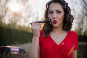 Portrait of woman applying make-up with make-up brush