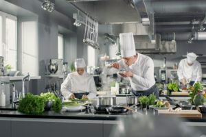 chef-plating-food-in-busy-restaurant-kitchen