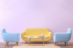 A pastel yellow couch and two light blue armchairs on a throw rug