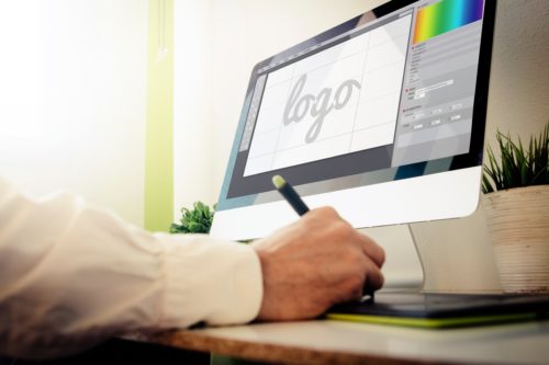 Man works at desk on a logo design